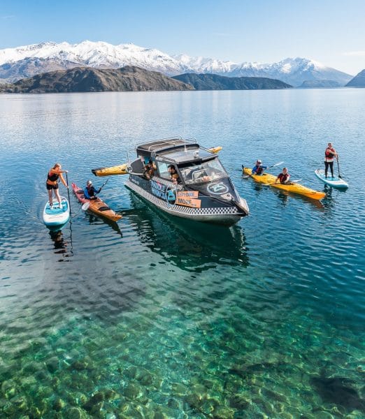 Boat with kayak and paddleboards and kayaks on the lake